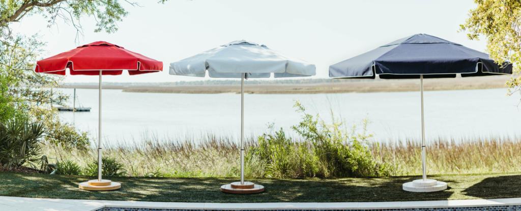 Three Palmetto Umbrellas sitting by a poolside - the Charleston marsh in the background