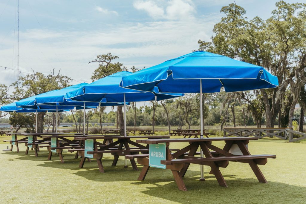 Five Capri Blue Outdoor Umbrellas connected to picnic tables at a local brewery