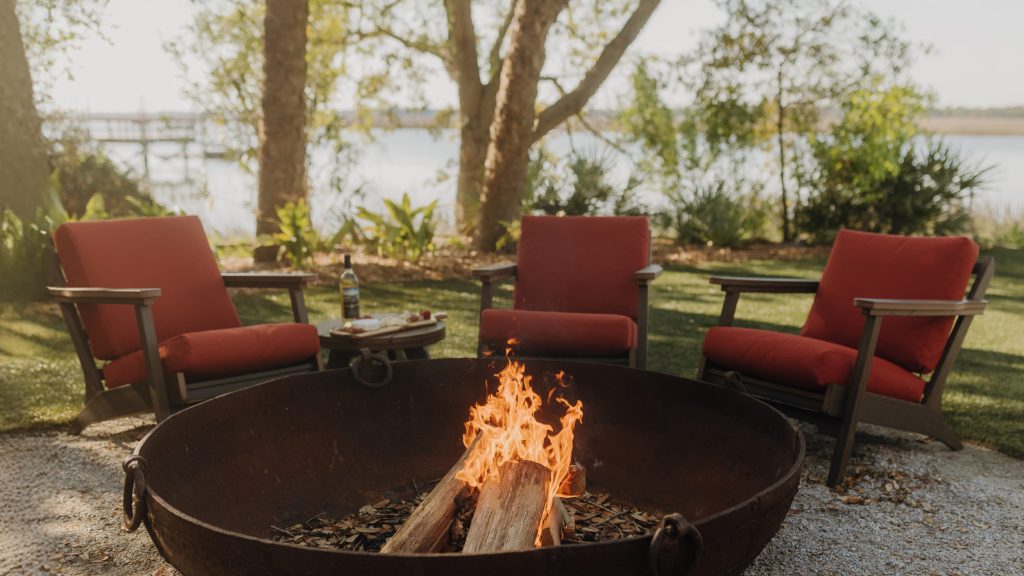 Three Bourbon chairs near a firepit in the afternoon sun